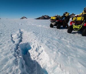 2 quads parked next to a crevass