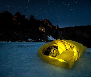 A man in his bivvy bag on the ice at Rumdoodle
