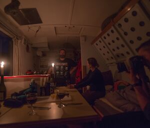 3 people inside Fang hut with table set for dinner