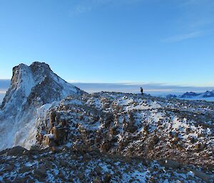 A man on a ridge line overlooking Mt Parsons