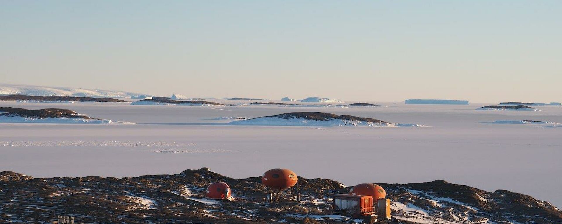 The huts on Béchervaise Island with iceberg alley on the horizon