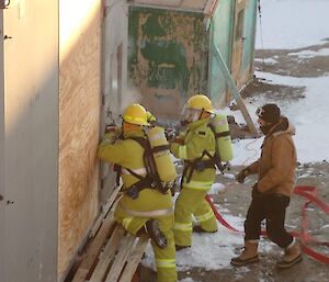 2 people in BA gear prepare to enter the smoked-up building