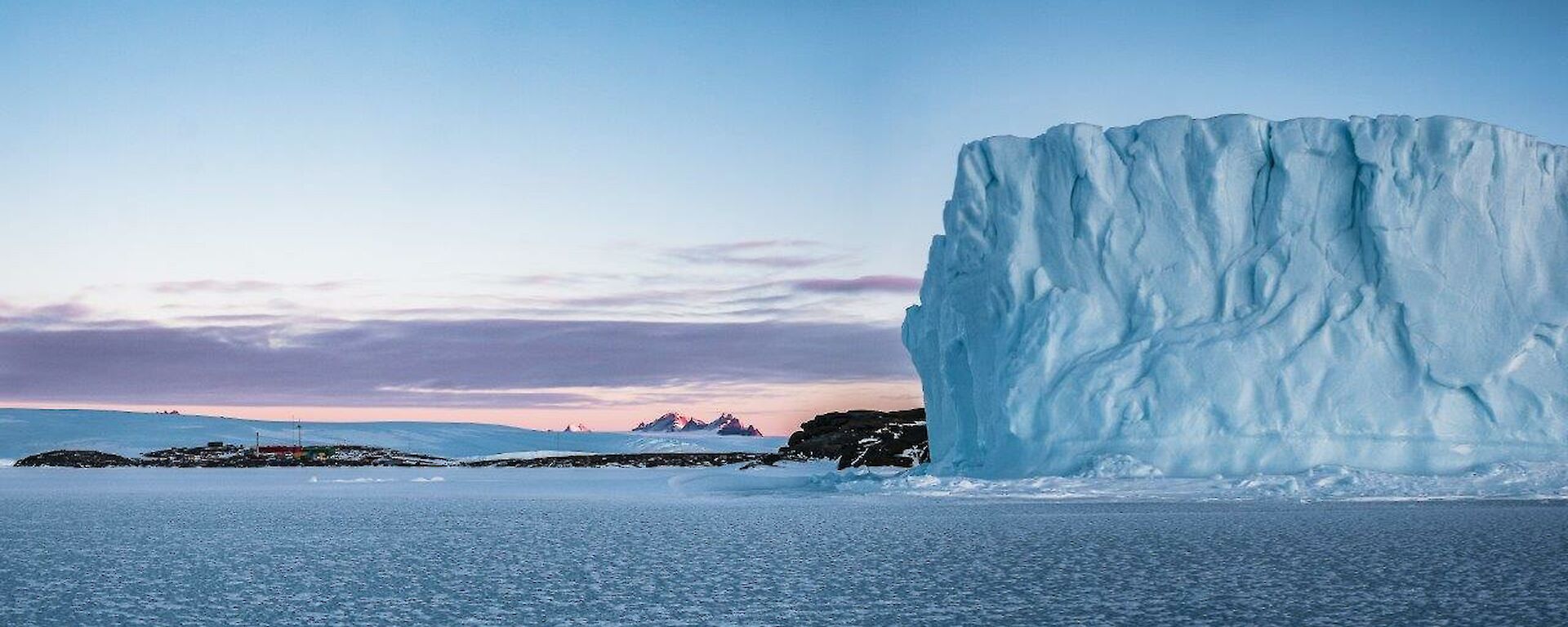 Pink sky and iceberg in the middle of the day