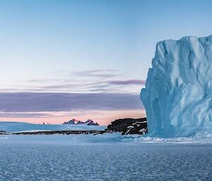 Pink sky and iceberg in the middle of the day