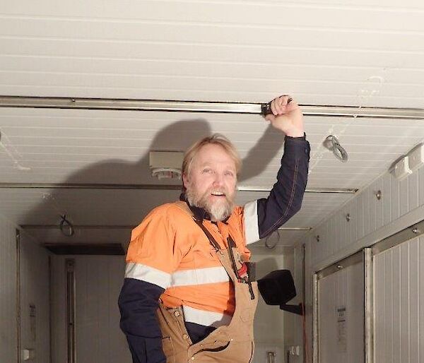 A man on a ladder at work in a container