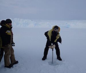 A man drills the sea ice to check its thickness