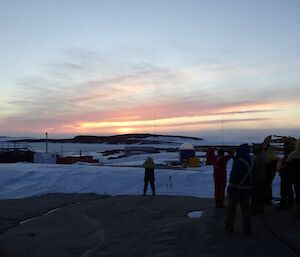 A group of people watch the sunset