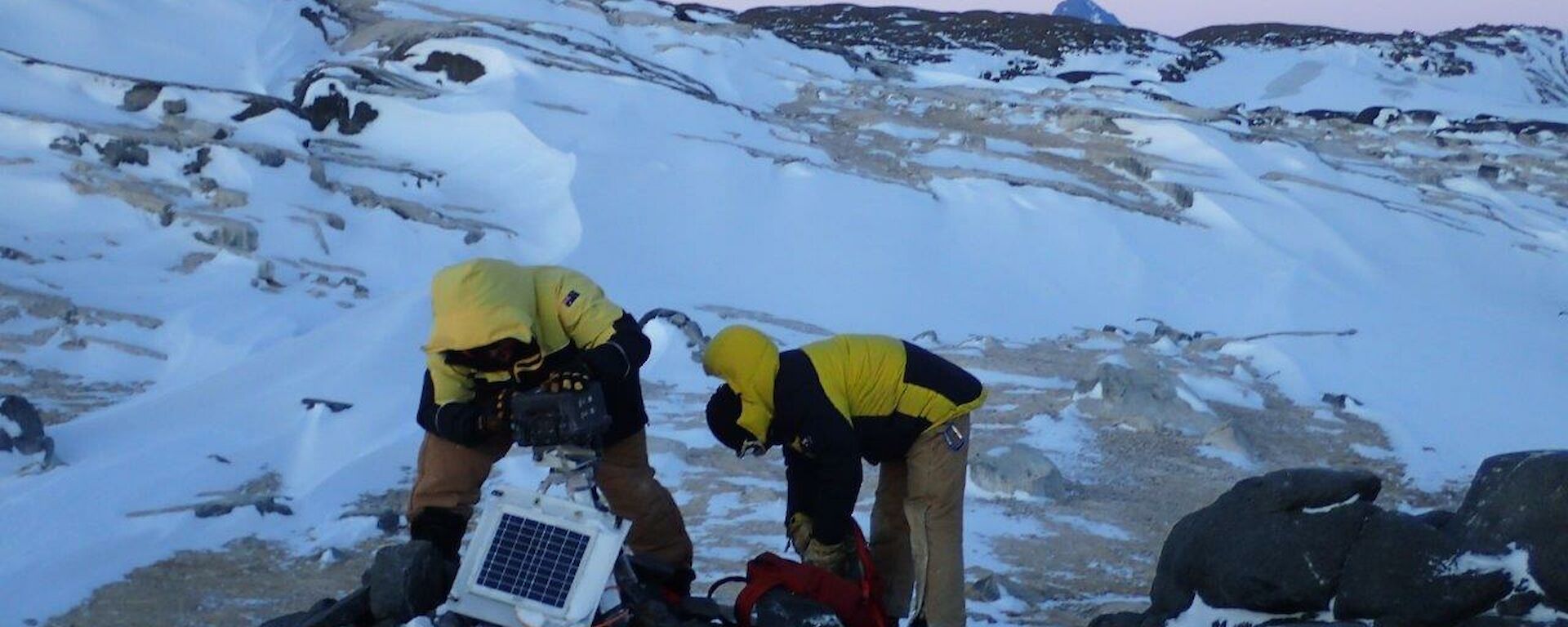2 men changing camera cards at one of the penguin cameras