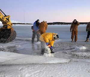A man cutting the sea ice with a chain saw