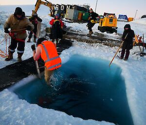 A man goes swimming in the ice in a hi-vis vest