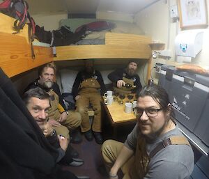 A group of men crammed into a hut