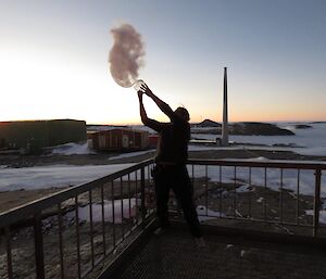 A man throws boiling water in the air to make clouds