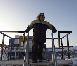 A man stands on top of a fuel tank