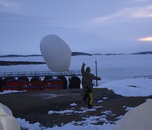 A man lets go of the weather balloon
