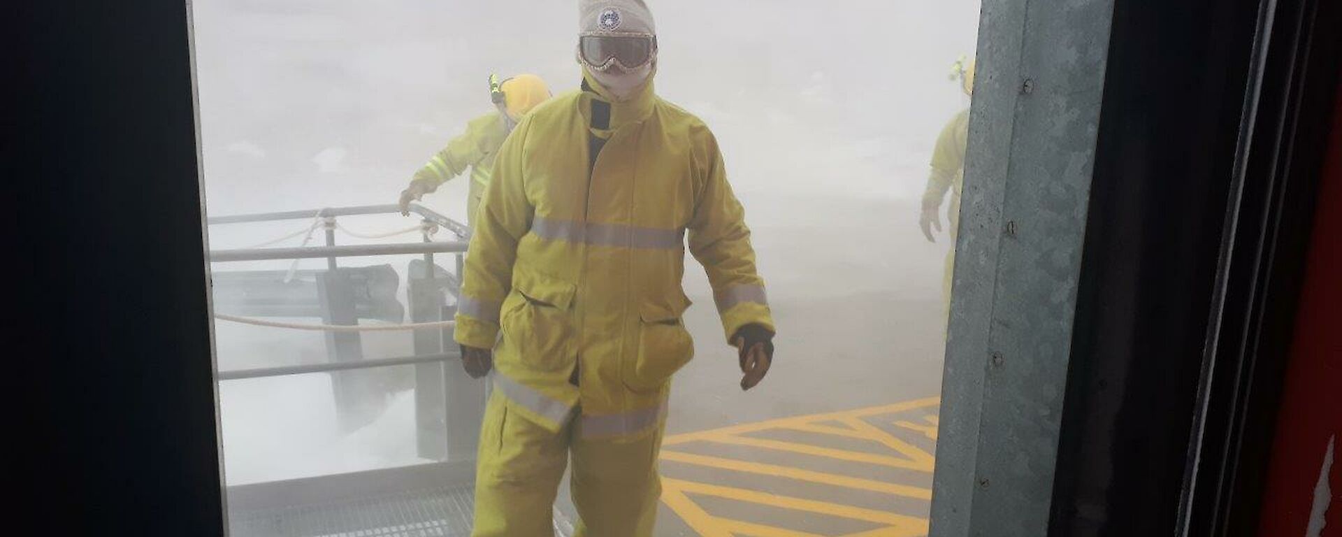 A man in fire clothing walks out of the blizzard