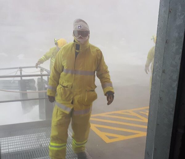 A man in fire clothing walks out of the blizzard