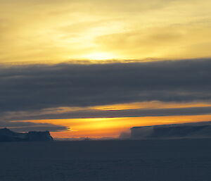 A sunrise sky with icebergs
