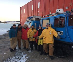 6 people pose for camera in front of Blue Hagg