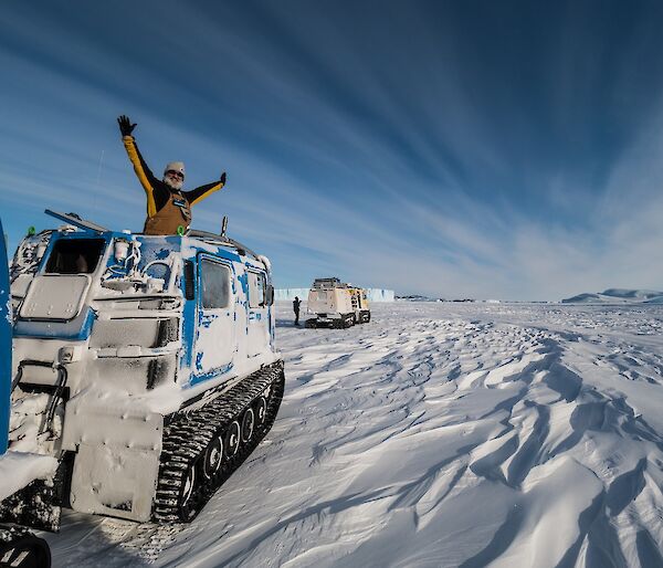 Person standing with arms out of Hägglunds.