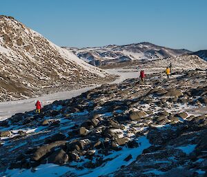 People walking up a hill looking for a cache.