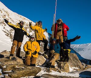 Group of people standing together around a pole.