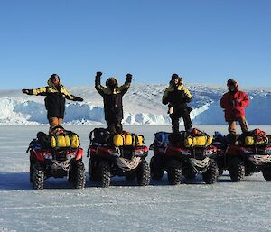 4 men post on top of quad bikes