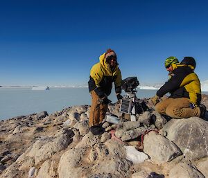 Two men working on a penguin observation camera