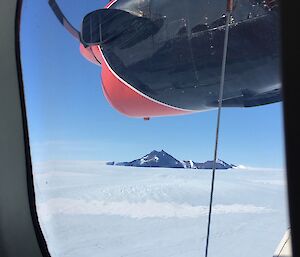 a view of mountains through the ice from a plane