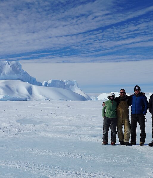 5 people pose on the sea ice