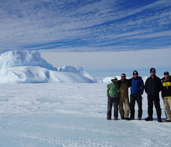 5 people pose on the sea ice