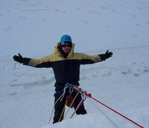 A man is held by the rope system over the edge