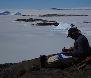 A man takes notes overlooking the ice