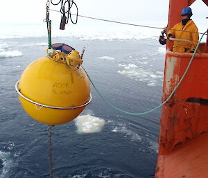 Deploying one of the large yellow buoys on a sub-surface mooring during a marine science voyage. (Photo: Wendy Pyper)