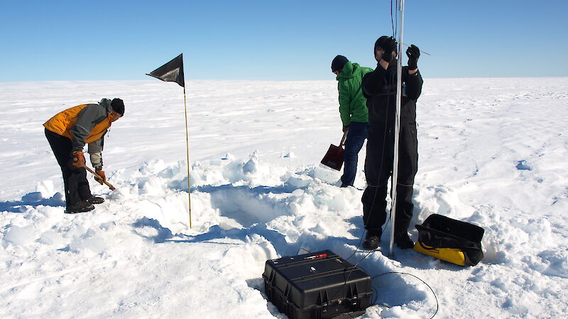 A team of 3 people digging a hole to install an ApRES instrument on the surface of the Sørsdal Glacier.