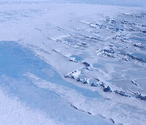 Liquid water visible beneath a thin layer of ice on the surface of the Sørsdal Glacier.