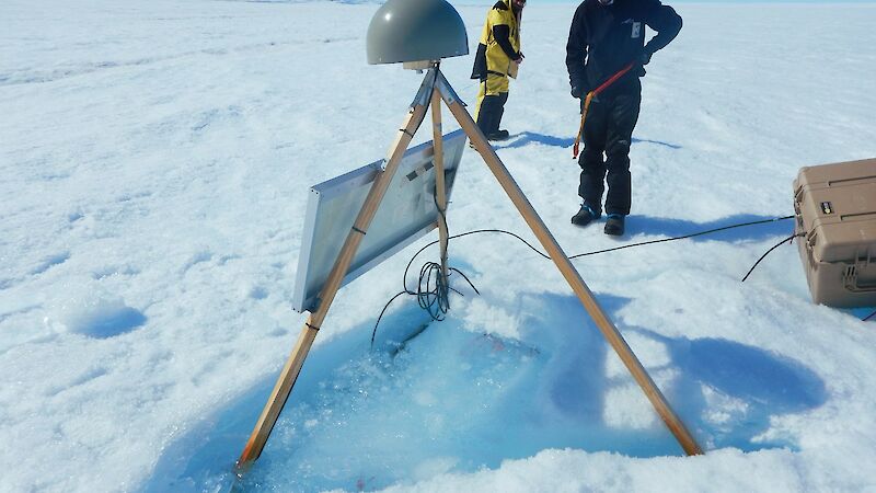 An expeditioner examines the melt pond at the base of the GPS on the Sørsdal Glacier.