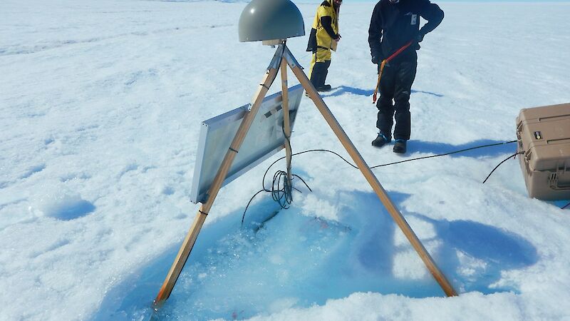 An expeditioner examines the melt pond at the base of the GPS on the Sørsdal Glacier.