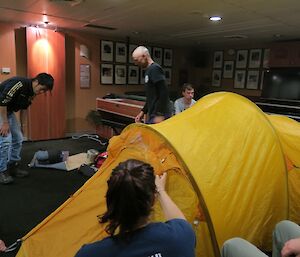 Expeditioners on the ship with a pitched tent.