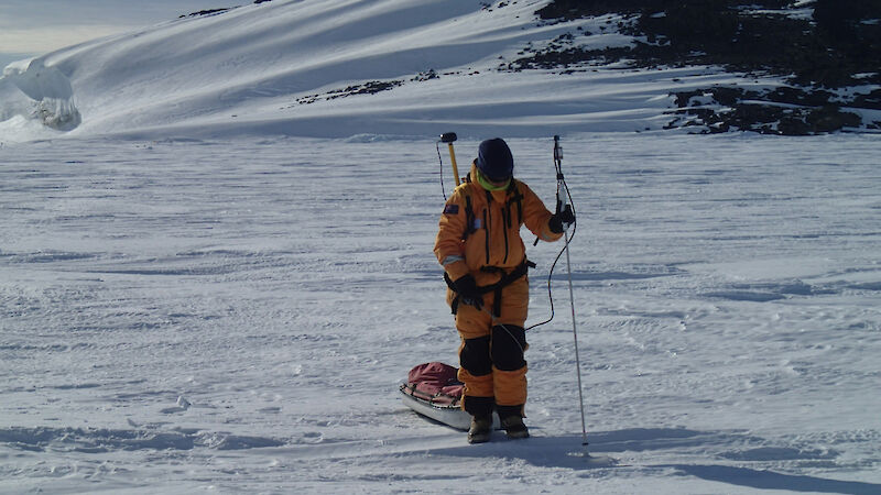 Expeditioner measuring and recording snow depth and GPS position using a GPS-MagnaProbe device.