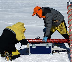 Two expeditioners working on the ice core drill