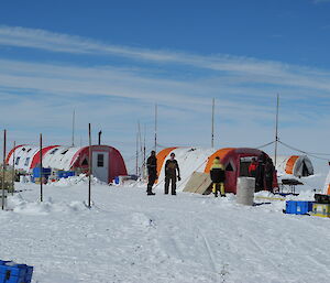 Five expeditioners negotiating near the Weatherhaven tent at the campsite