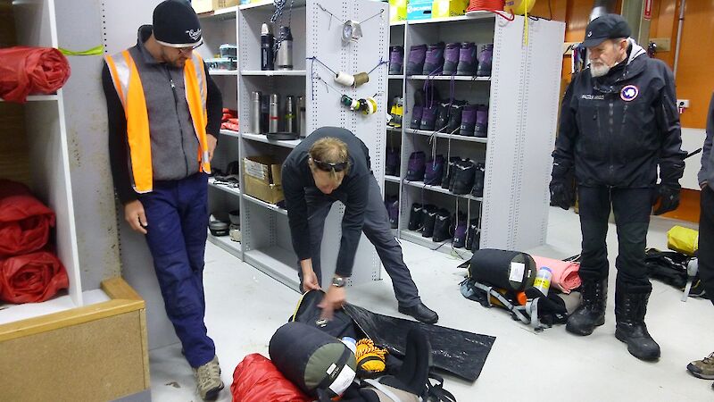 Three expeditioners packing their back packs with field training equipment