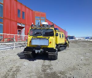 A yellow Hägglunds outside Casey’s red shed.