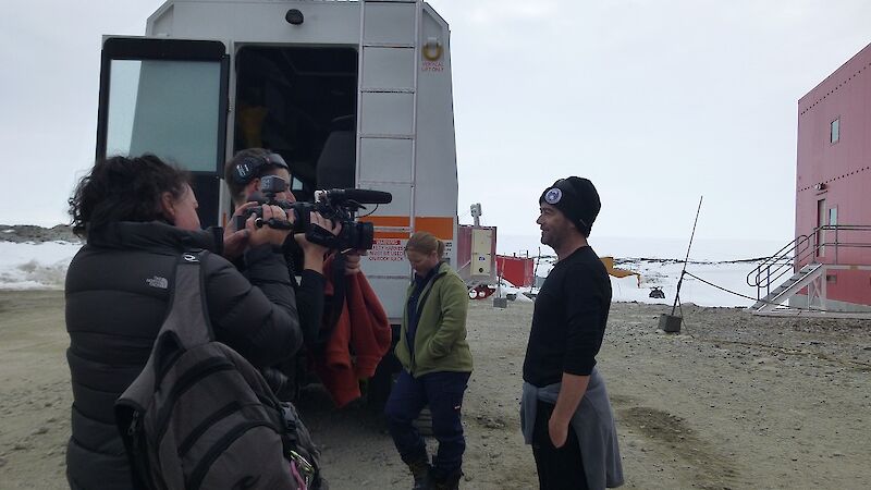 Science leader Dr Mark Curran stands in front of a group of media outside the Red Shed at Casey station.