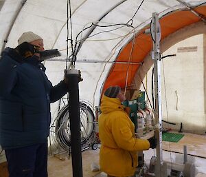 Scientists adjust the ice coring and firn air drilling equipment.
