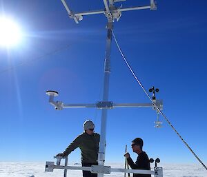 Two Aurora Basin team members set up an automatic weather station.