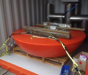 The round, orange sea ice buoy that will carry power and communications cables from the surface of the sea ice to the underwater chambers