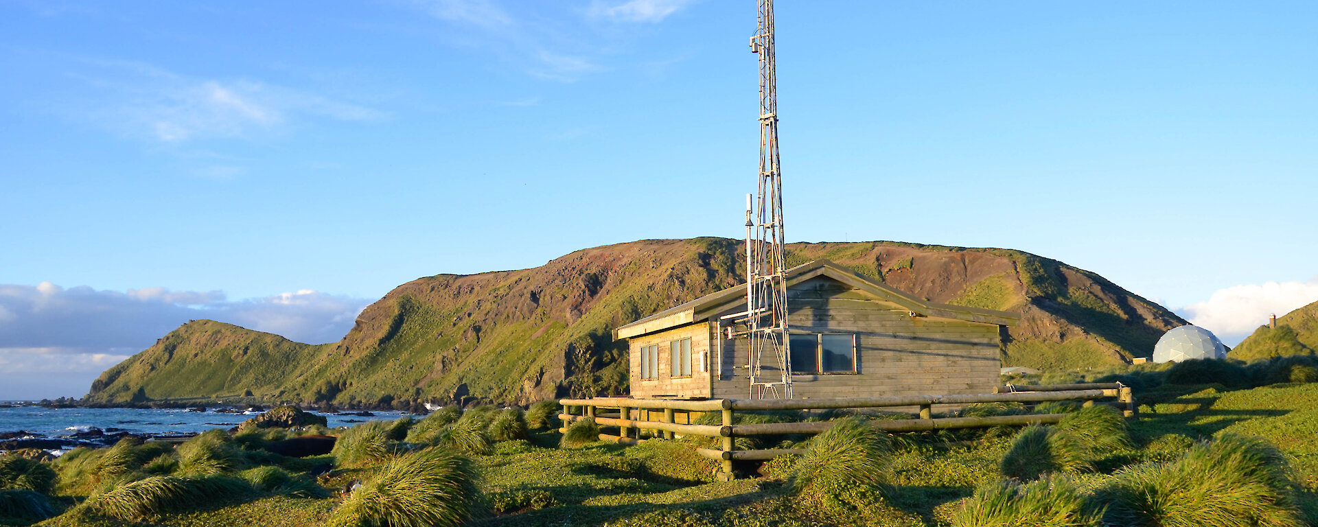 Timber building with steep hill behind