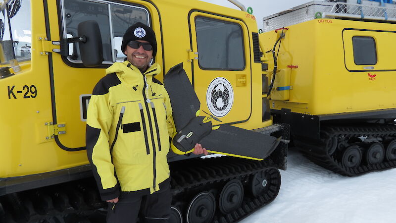 James Rennie with the fixed-wing Sensefly eBee drone, standing beside a Hagglund in Antarctica.