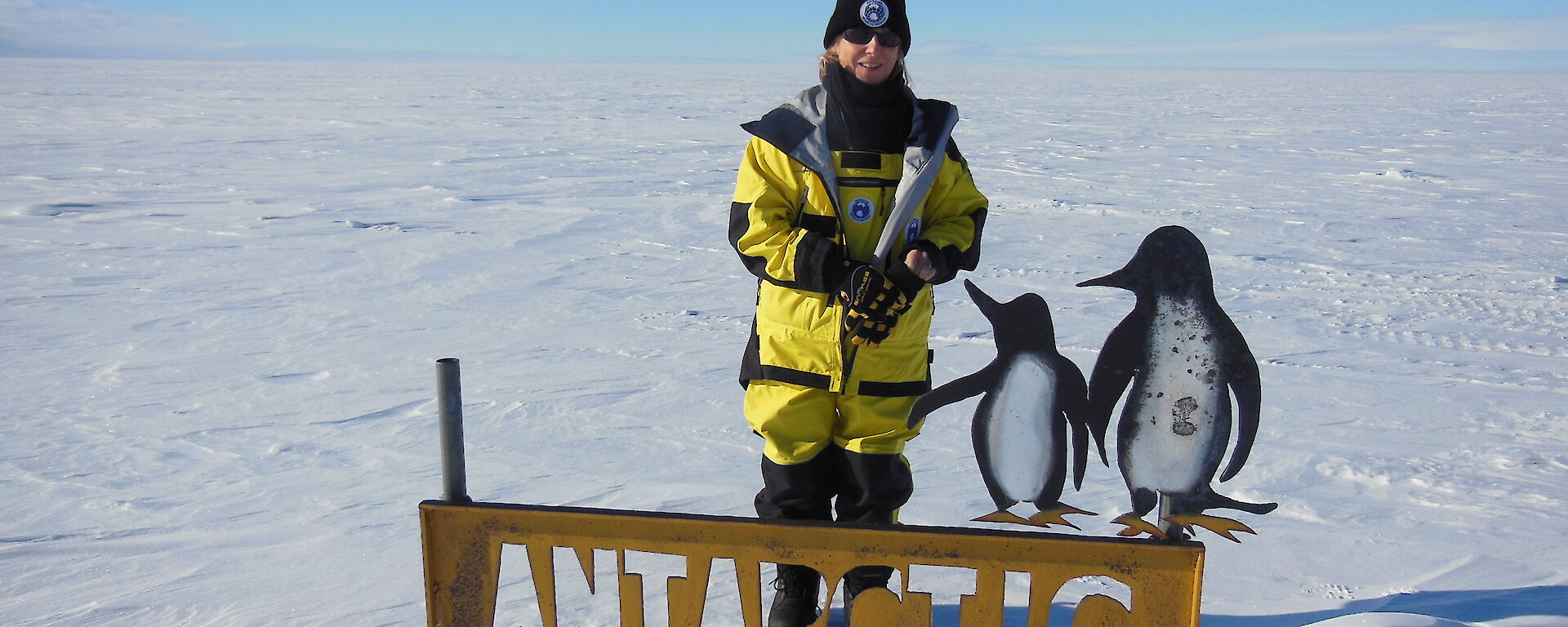 Gwen beside the Antarctic Circle sign.